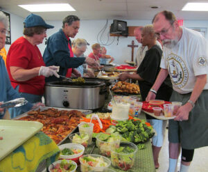 Volunteers serving surplus food to community members as part of a food waste reduction initiative.